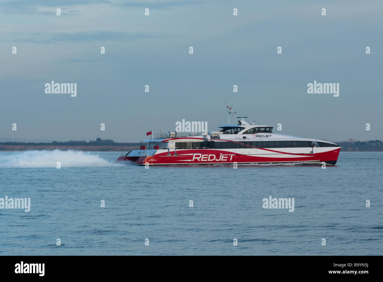 Red jet hi-speed catamaran ferry crossing the Solent between Southampton and West Cowes on the Isle of Wight Stock Photo