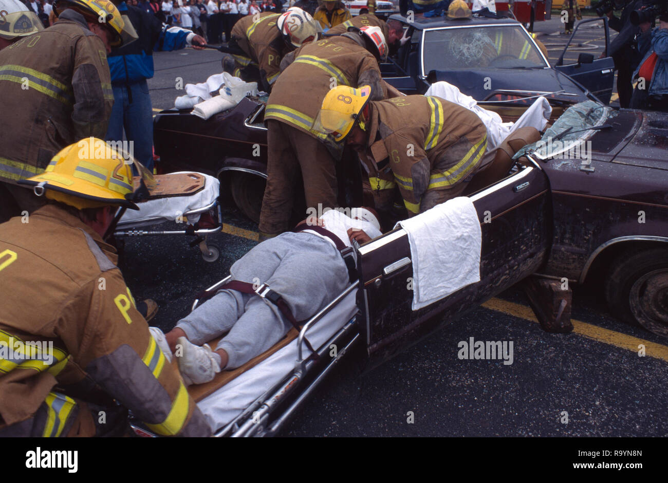 firefighters remove an injured person r esult of an auto accident Stock Photo