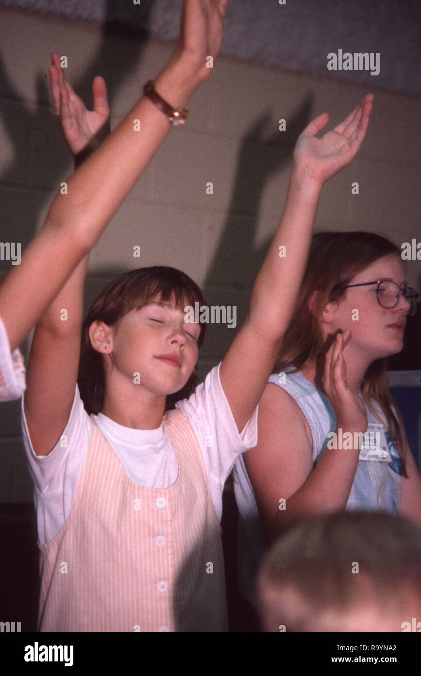 Young girl worships God during a church service Stock Photo