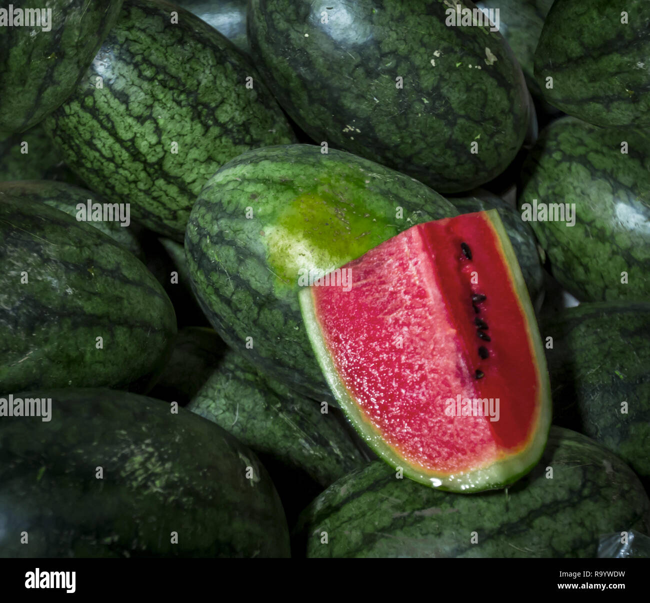 wedge of red cut watermelon laying on whole melons Stock Photo Alamy