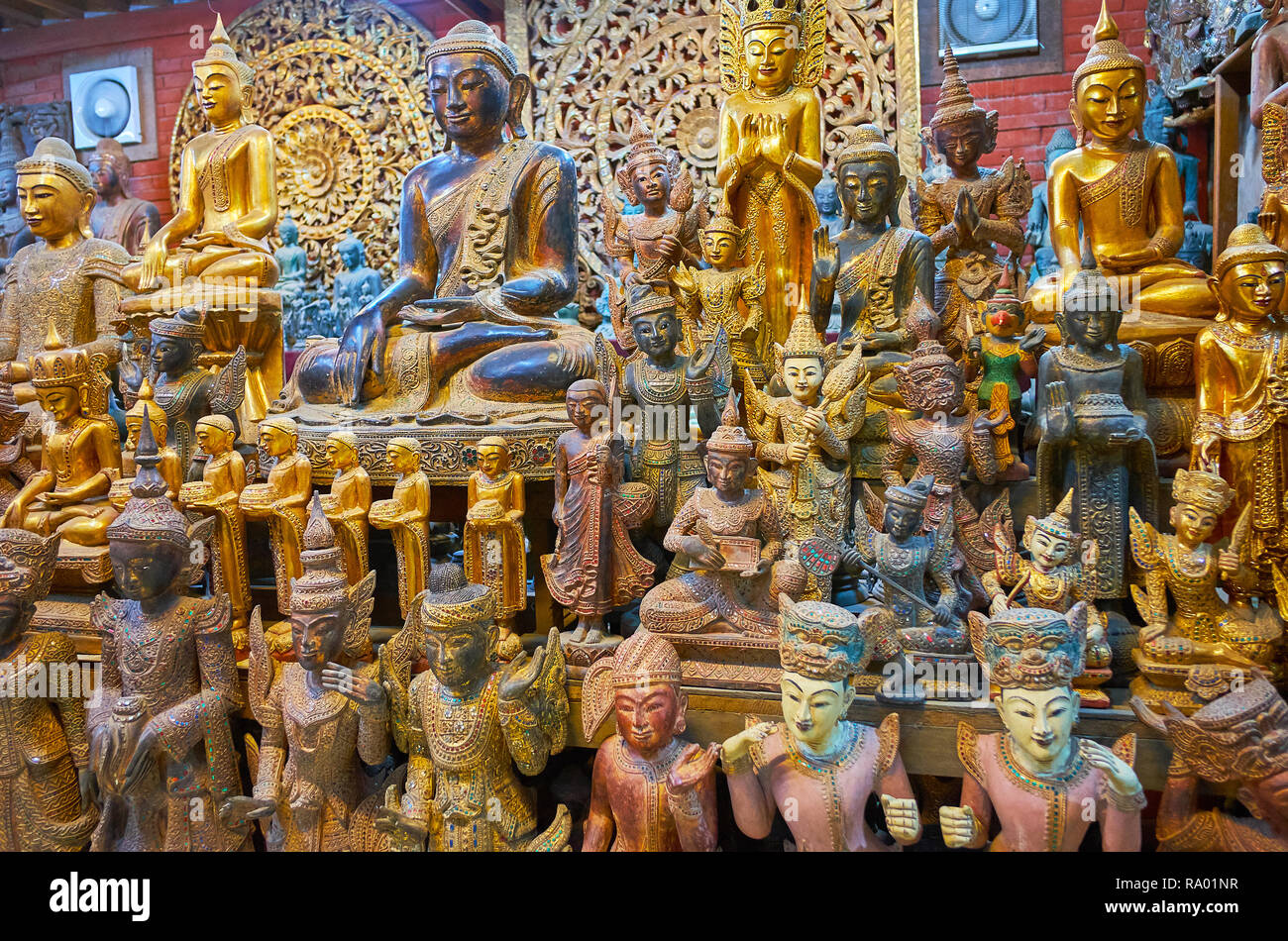 The large amount of masterpiece handmade wooden sculptures in workshop of Shwe-gui-do quarter, Mandalay, Myanmar. Stock Photo