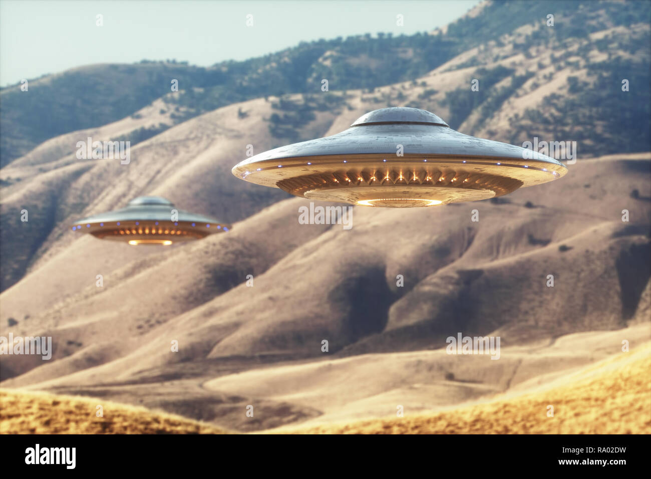 Two unidentified flying objects - UFO, flying over the sunny desert. Stock Photo