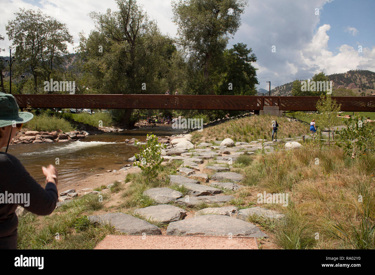 People walk along Boulder Creek which runs through Boulder, Colorado