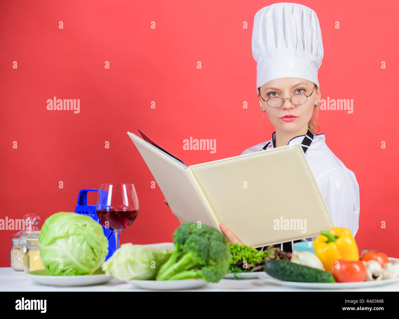 Culinary expert. Woman chef cooking healthy food. Girl read book top ...