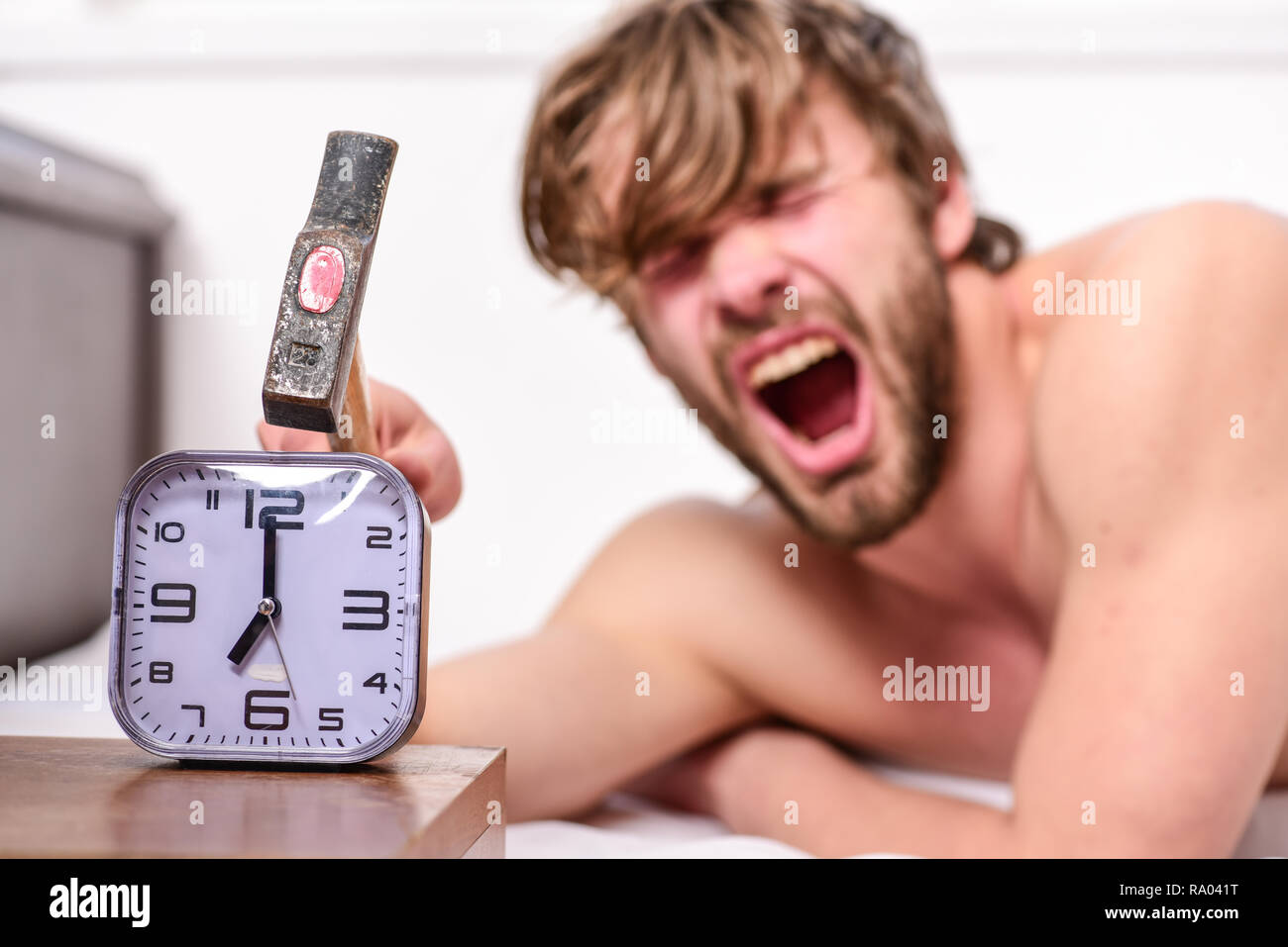 Man bearded annoyed sleepy face lay pillow near alarm clock. Break  discipline regime. Stop ringing. Annoying sound. Annoying ringing alarm  clock. Guy knocking with hammer alarm clock ringing Stock Photo - Alamy
