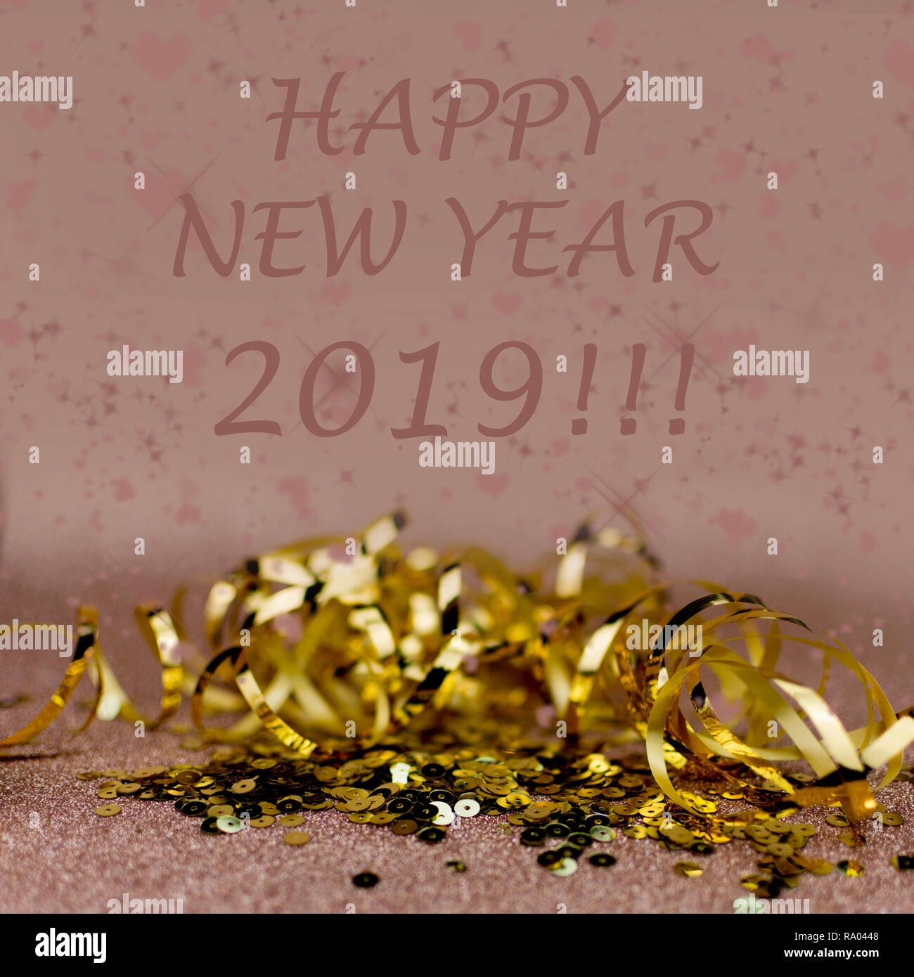 New Year 2019 greetings card. Golden ribboon and sequins on warn soft pink background. Stock Photo