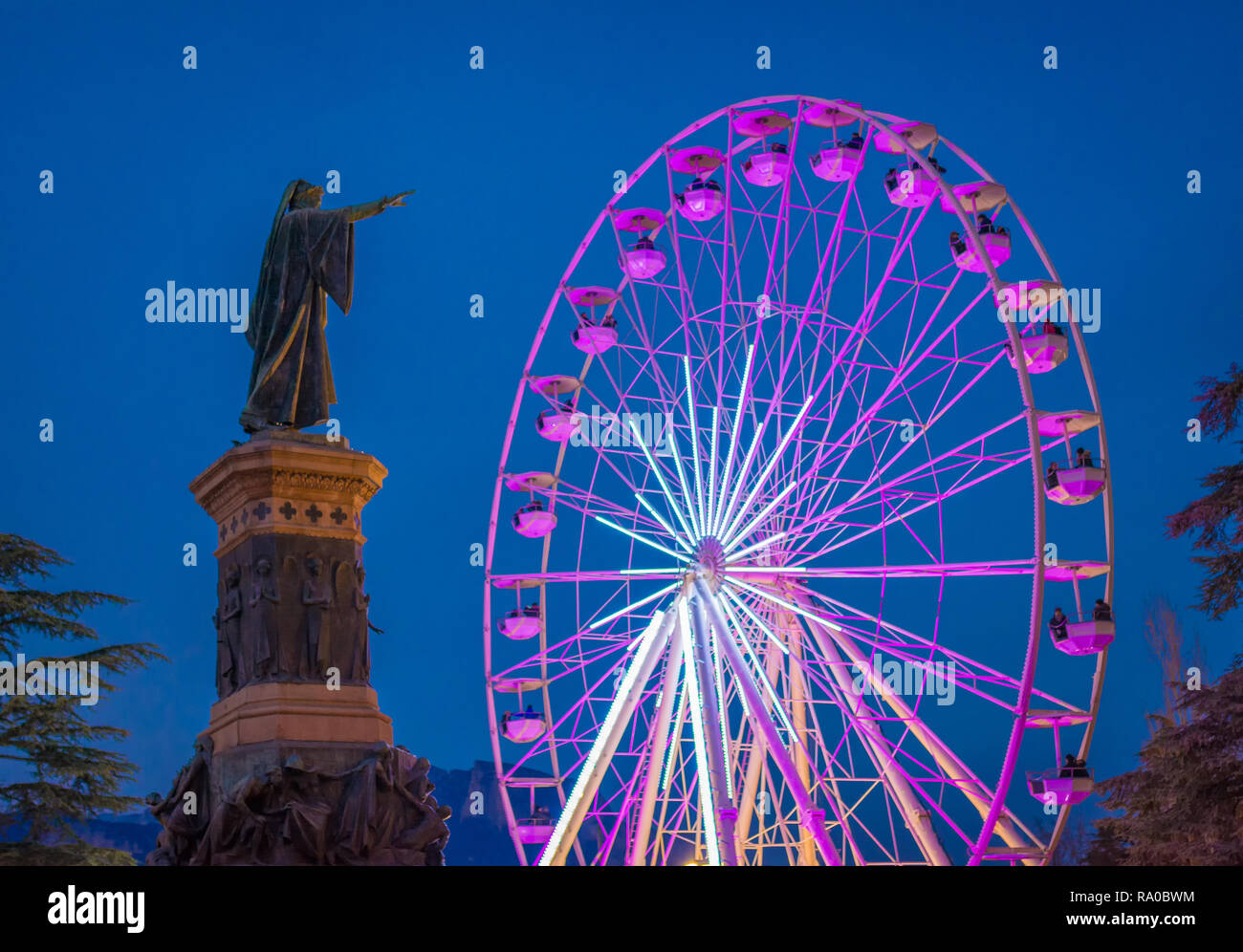 The big panoramic wheel in Dante Alighieri square in Trento city at night during the Christmas festivity. Christmas market in Trento, Trentino Alto Ad Stock Photo