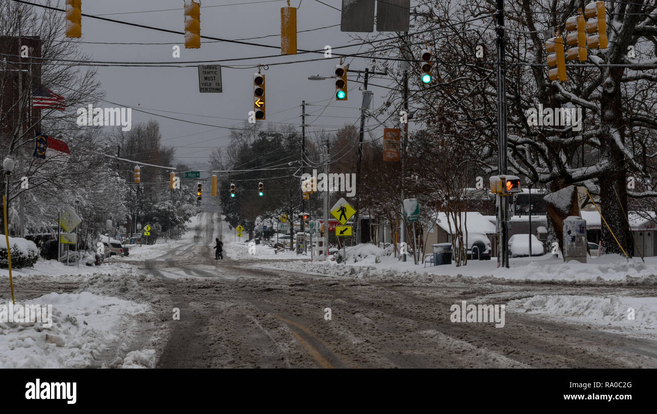 People crossing plowed street after snowstorm on cold winter morning Stock Photo