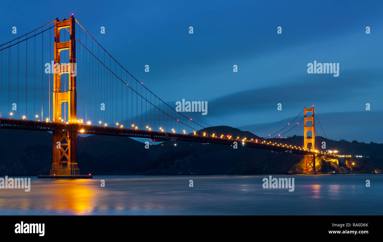 Nighttime view of Golden Gate Bridge on a dark blue sky background; California Stock Photo