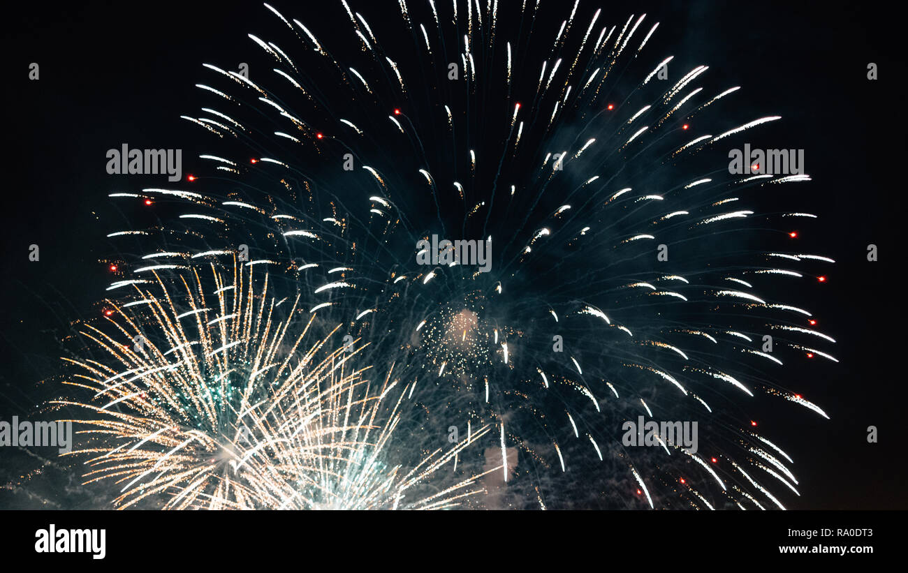 Exploding bright fireworks in dark night sky. Stock Photo