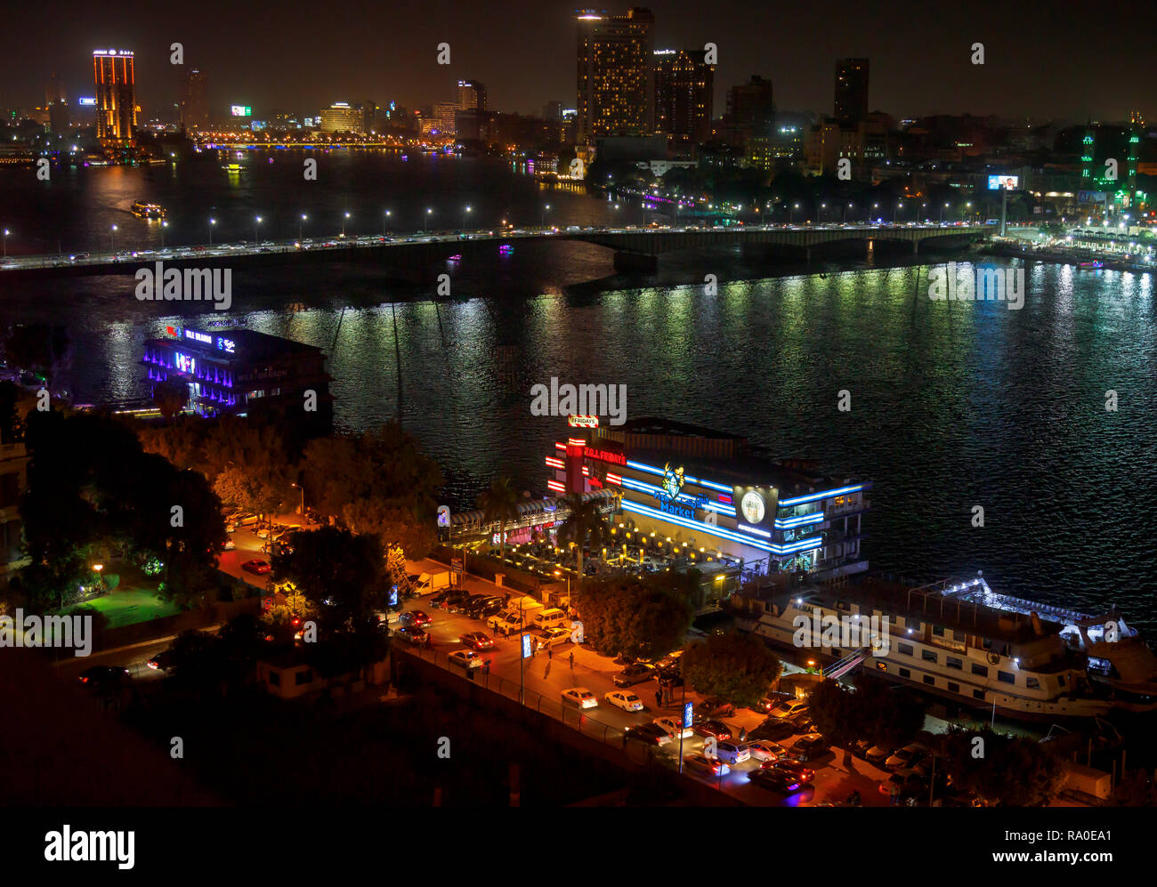 Floating restaurants, TGI Fridays, Grand CafŽ, Fish Market, on boats moored on the River Nile, Giza, Cairo, Egypt at night by Cairo University Bridge Stock Photo