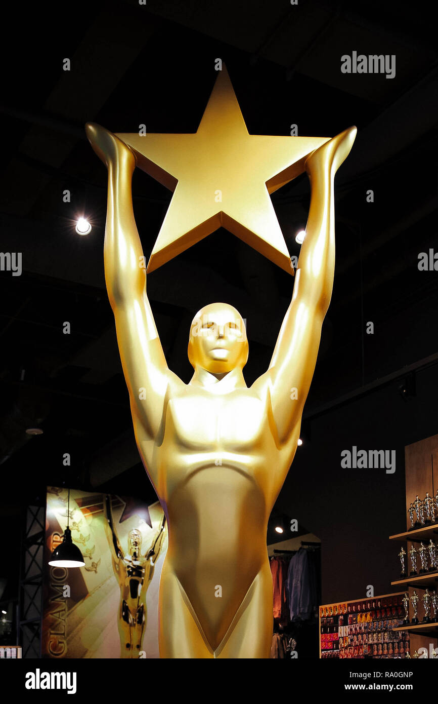 Hollywood, CA/ USA - July 26, 2018: Golden Oscar Statue holding gold star. Golden award or trophy is symbol of Success and Victory concept Stock Photo