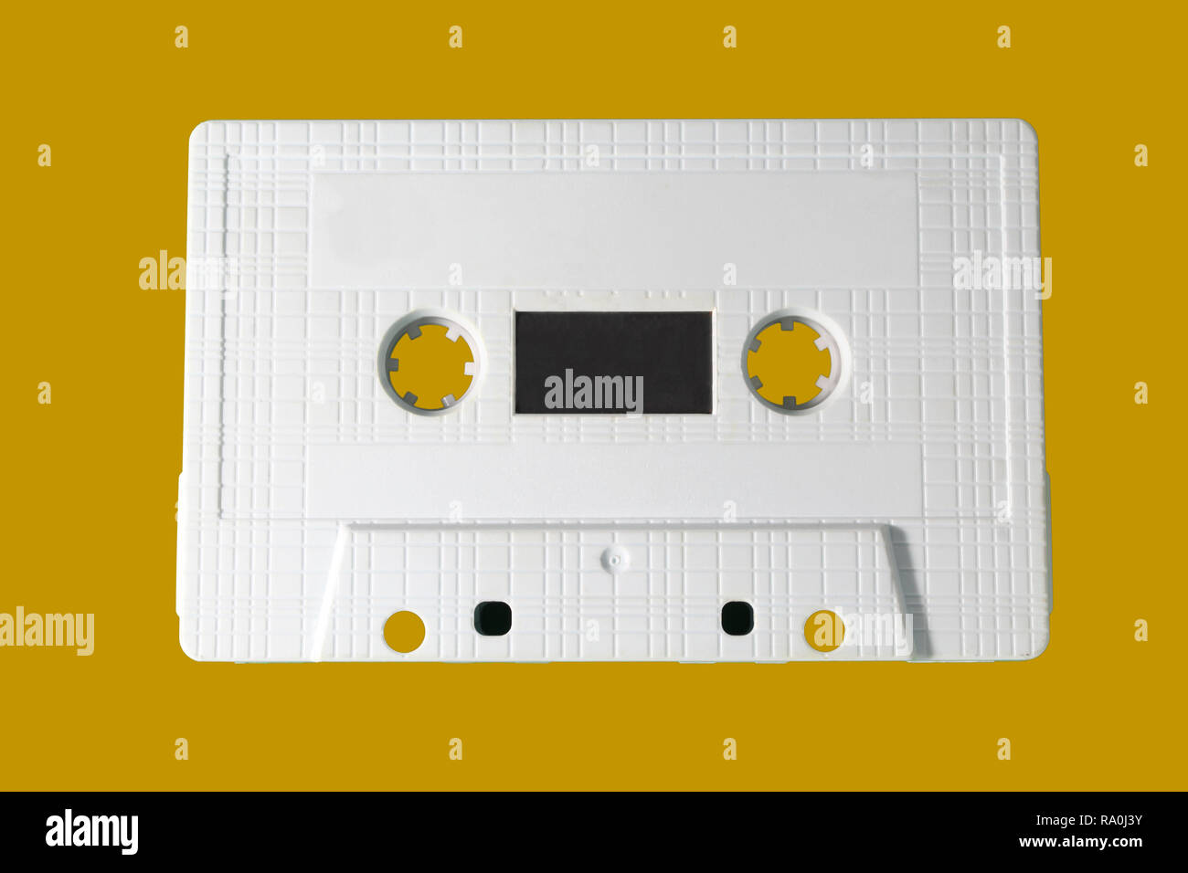 White audio cassette isolated on yellow background. Old vintage Cassette tape Stock Photo