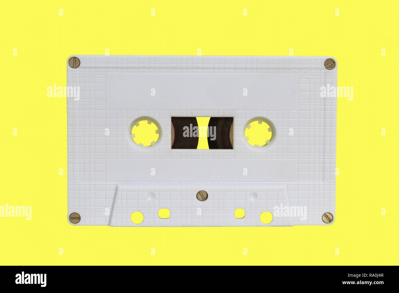 White audio cassette isolated on yellow background. Old vintage Cassette tape Stock Photo