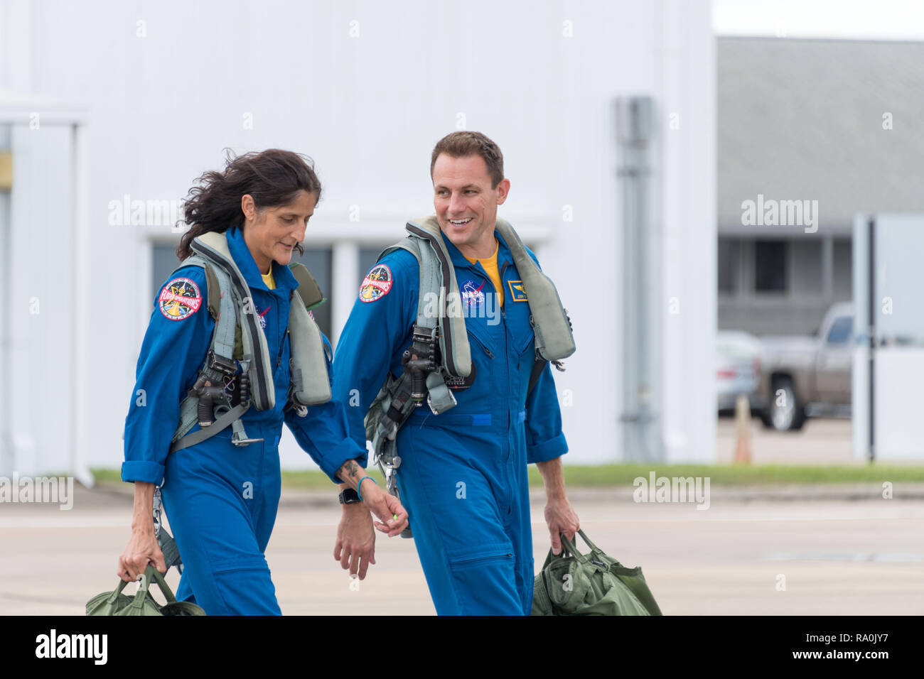 NASA commercial crew astronauts Josh Cassada, right, and Suni Williams walk across the tarmac as they prepare for T-38 training flights at Ellington Field Joint Reserve Base October 9, 2018 in Houston, Texas. Cassada and Williams are assigned to the Boeing Starliner second crewed flight. Stock Photo