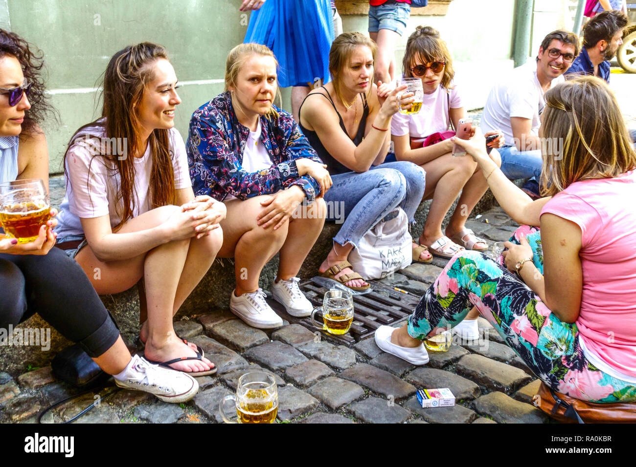 Street scene in summer People Women drinking beer outside bar, Tourists enjoying life drinking beers Walking tour short stop Prague Czech Republic Stock Photo