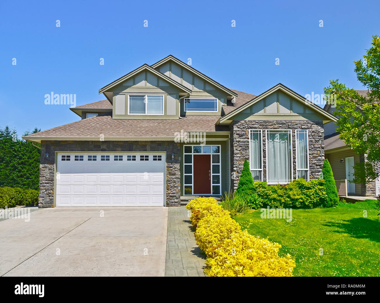 Luxury Family House With Concrete Driveway To The Garage On Blue