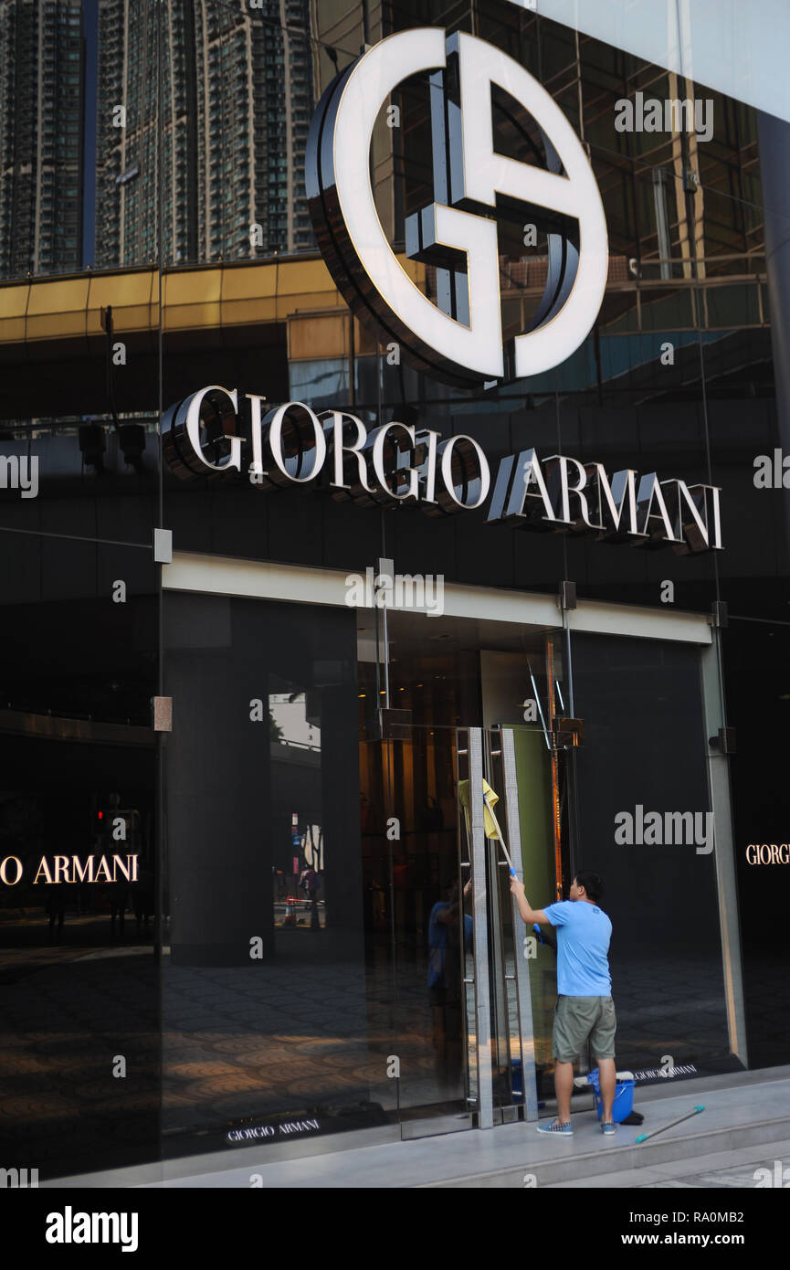 12.10.2014, Hongkong, Volksrepublik China, Asien - Ein Arbeiter reinigt die Eingangstuer eines Modegeschaefts der Marke Giorgio Armani in Hongkongs St Stock Photo