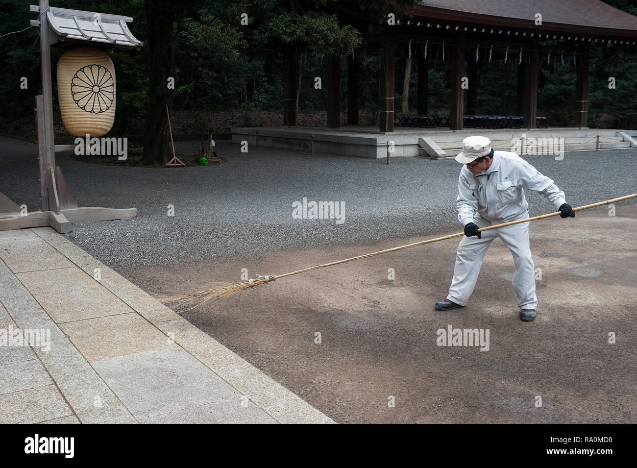 31.12.2017, Tokio, Japan, Asien - Ein Tempelarbeiter fegt mit einem Reisigbesen das Gelaende am Meiji-Schrein in Shibuya. 0SL171231D055CARO.JPG [MODEL Stock Photo