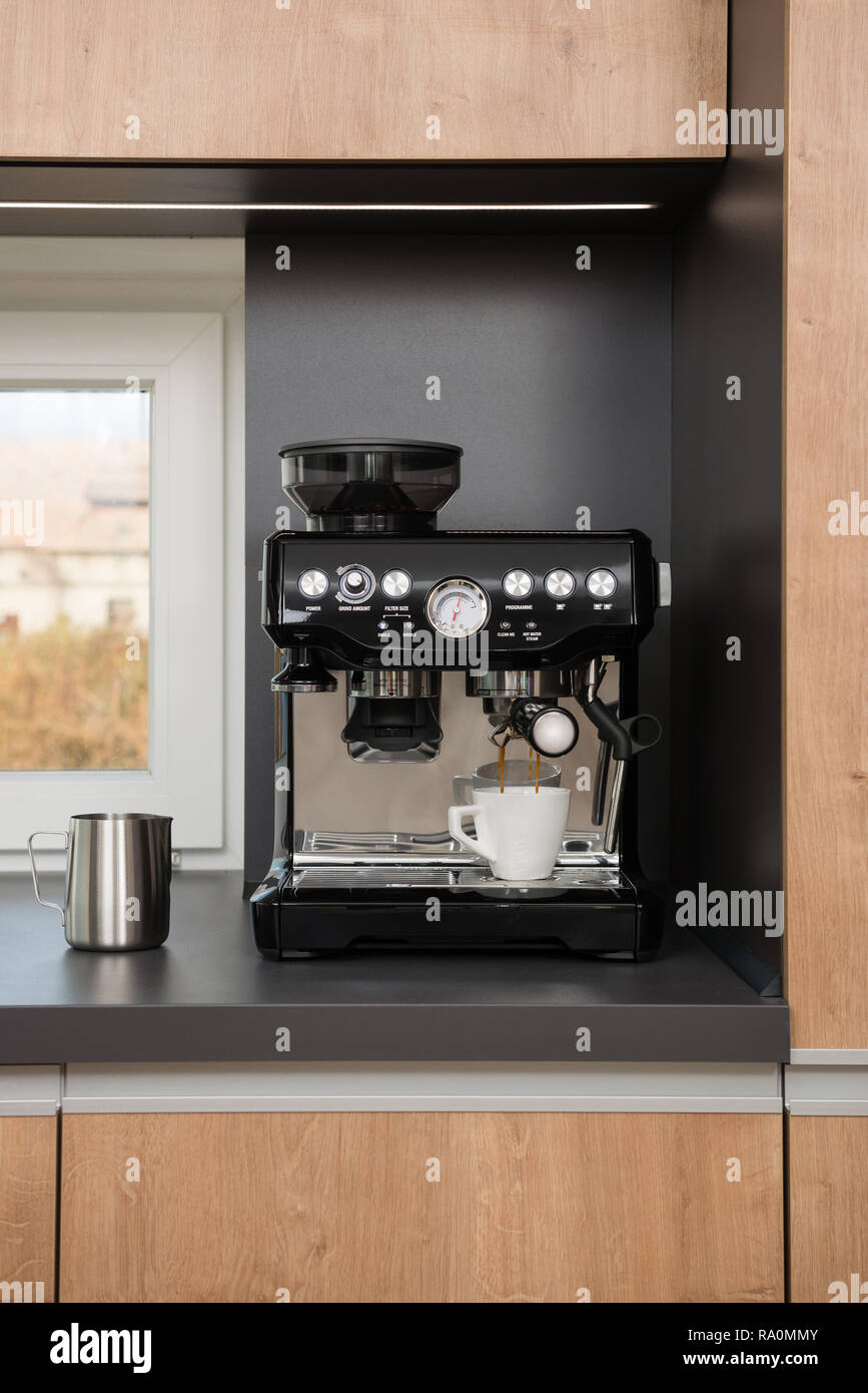 White cup of espresso in coffee machine Stock Photo