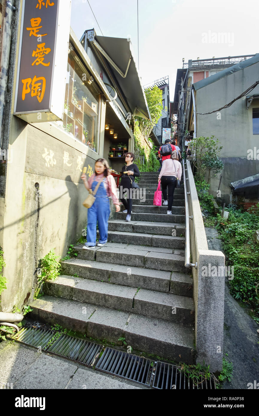 Jiufen, Taiwan - November 21, 2018: Tourist step up the stairs to Jiufen Village. This place is a travel destination in Ruifang District, Taiwan. Stock Photo