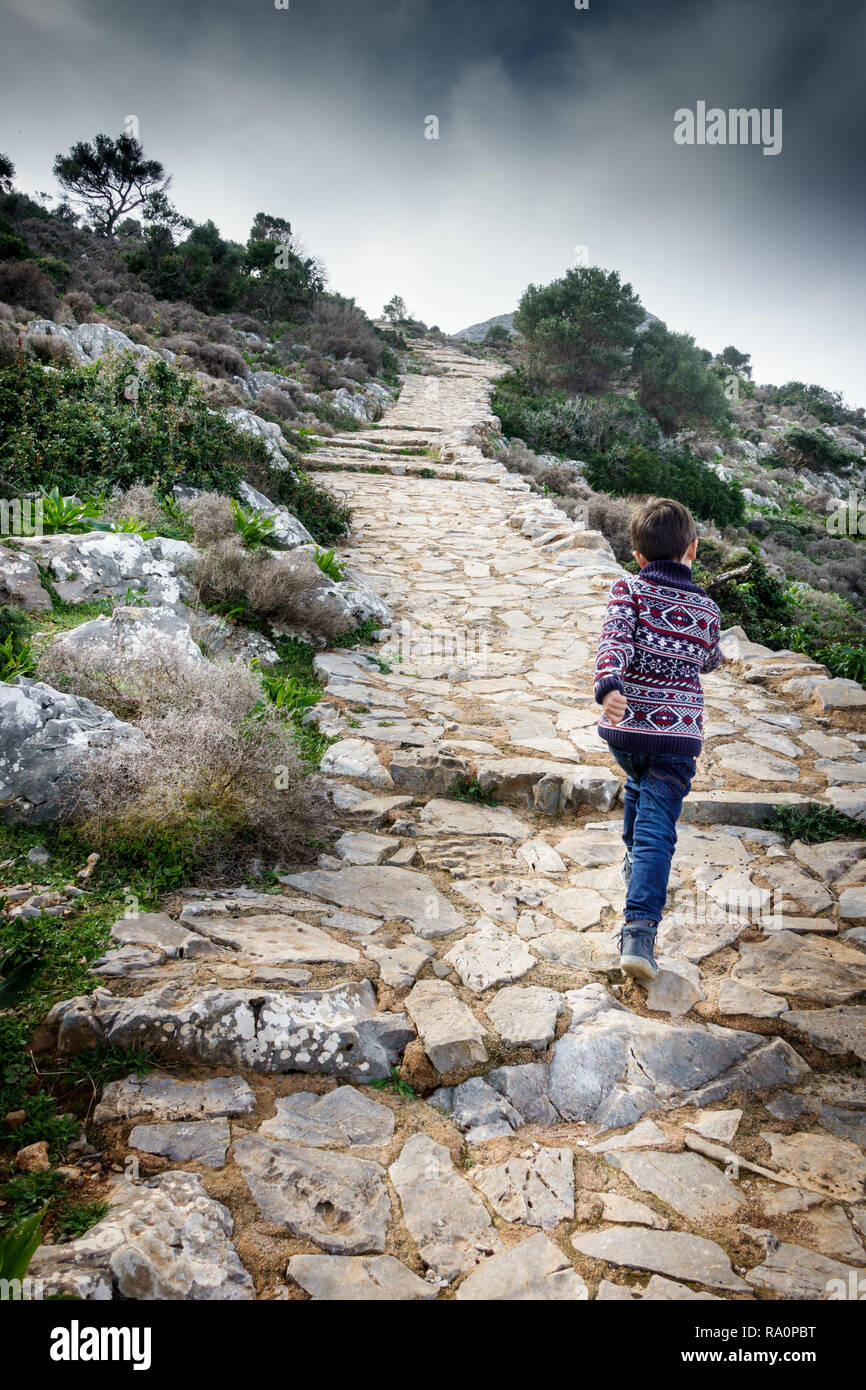 Rear view of boy walking uphill Crete Greece Stock Photo
