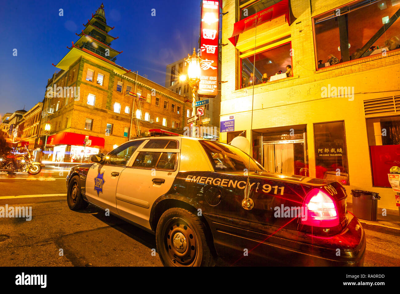 San Francisco, California, United States - August 16, 2016: wide angle view of police car with flashing lights on a street in Chinatown in San Francisco by night. Urban street view. Stock Photo