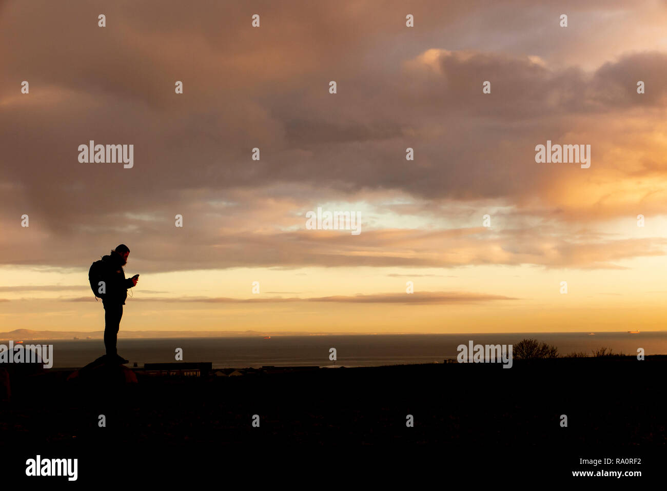 On top of the world - a back packer checks directions on a mountain in Scotland Stock Photo