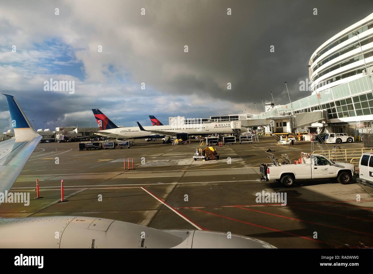 Menacing dark clouds encroaching sky above airport with airplanes at