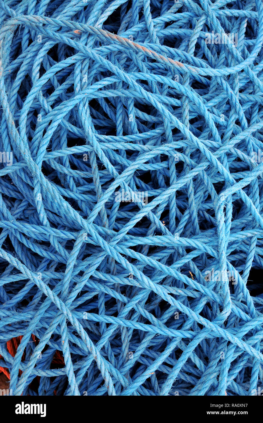 Detail of loose coils of blue  boating mooring rope / ropes at harbour. Stock Photo