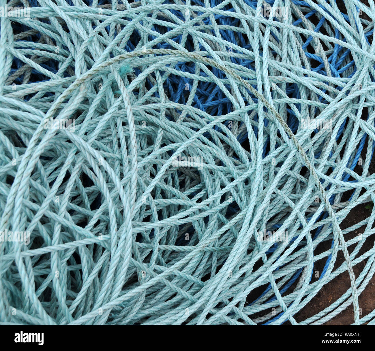 Detail of loose coils of blue  boating mooring rope / ropes at harbour. Stock Photo