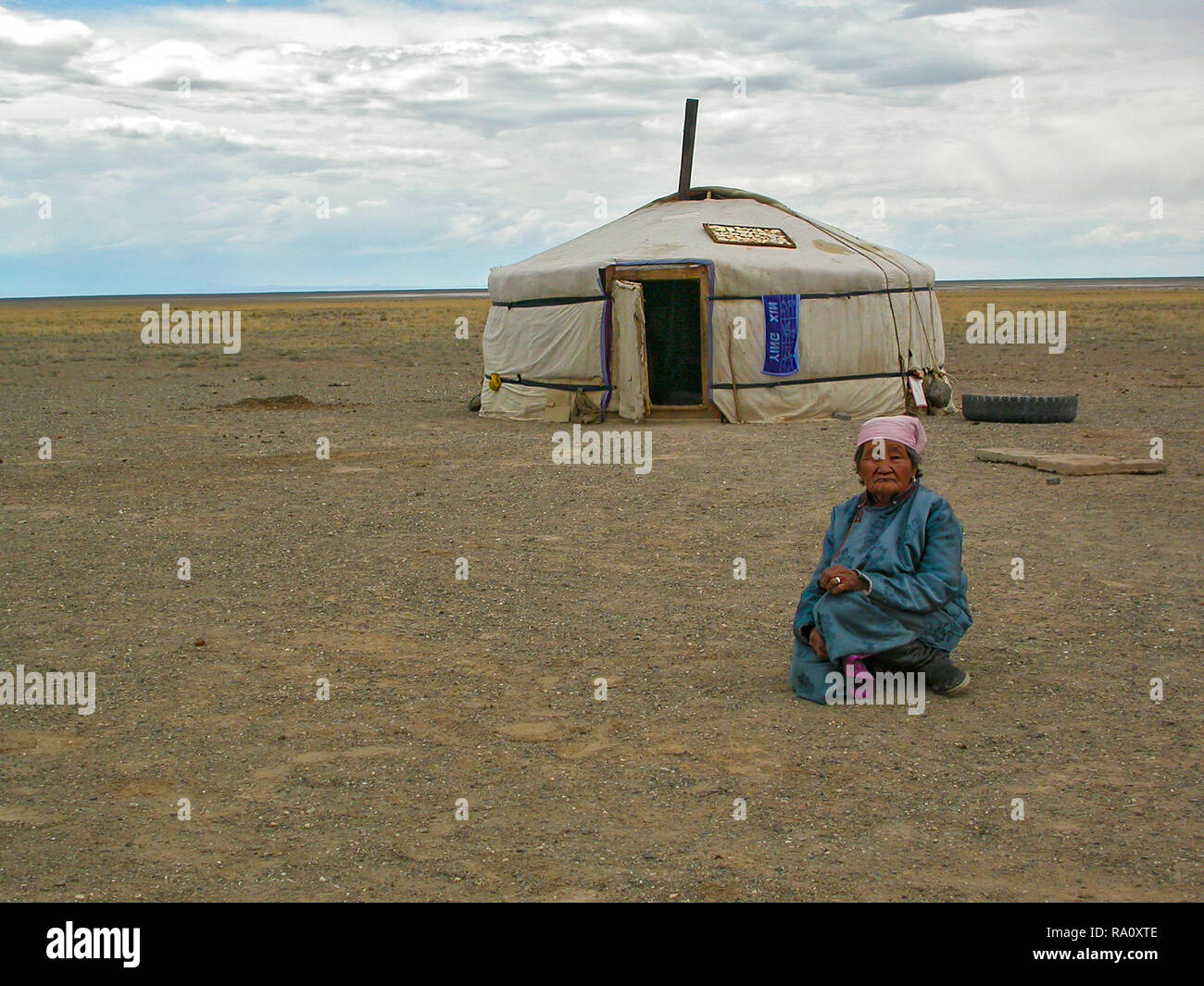 Old Mongolian woman sitting in front of yurt in open steppe countryside, Bulgan, Mongolia Stock Photo