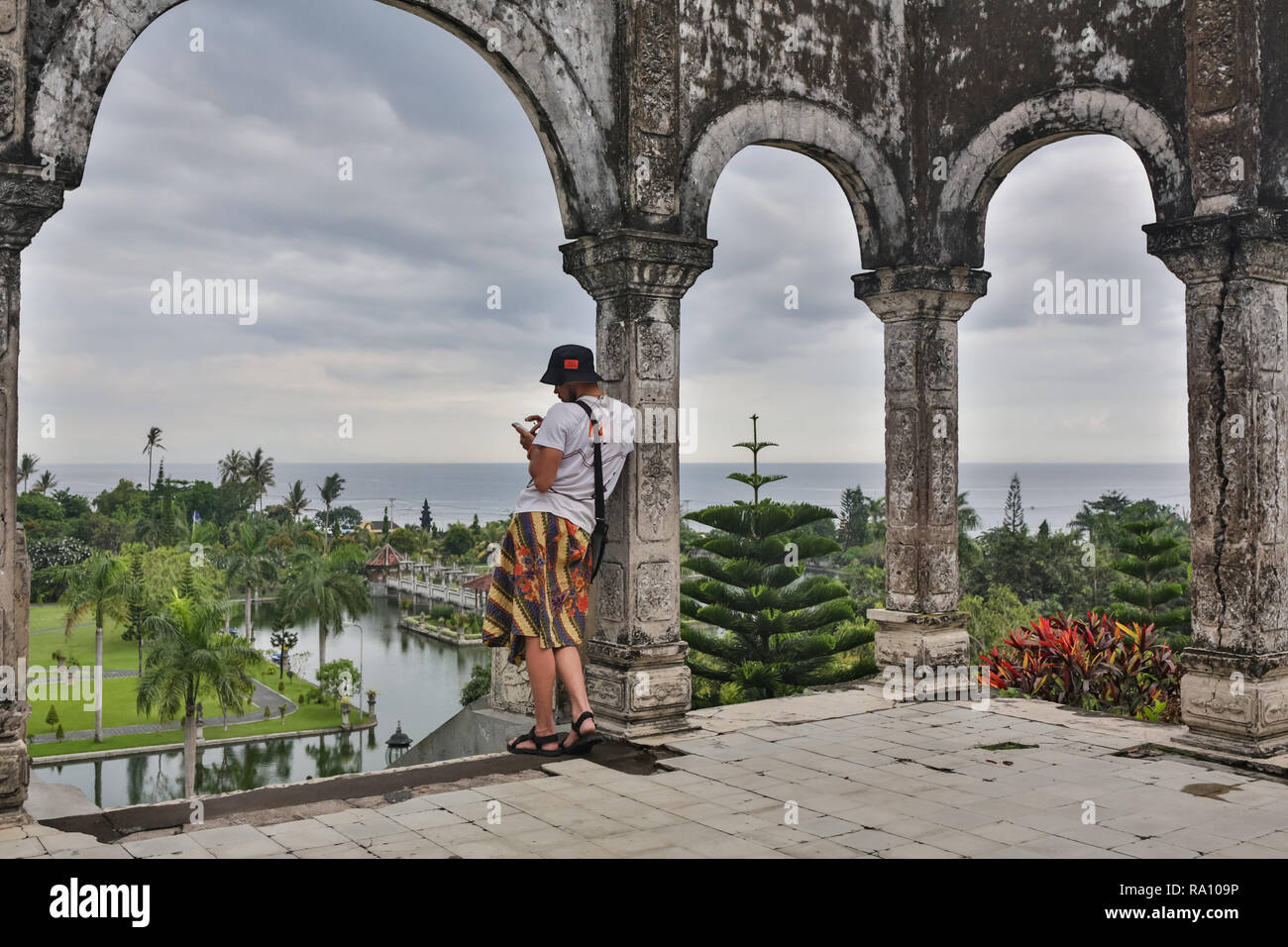 Young man tourist in old water palace on Bali island. Stock Photo