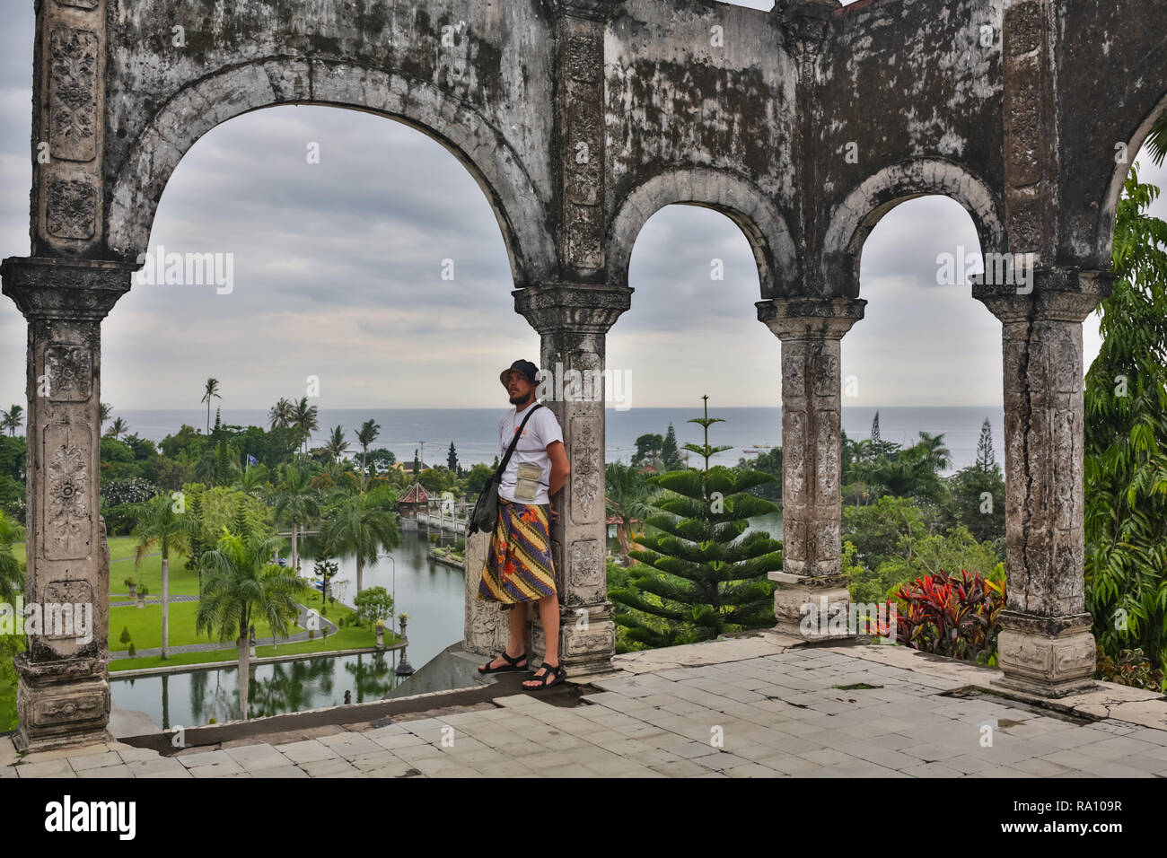 Young man tourist in old water palace on Bali island. Stock Photo