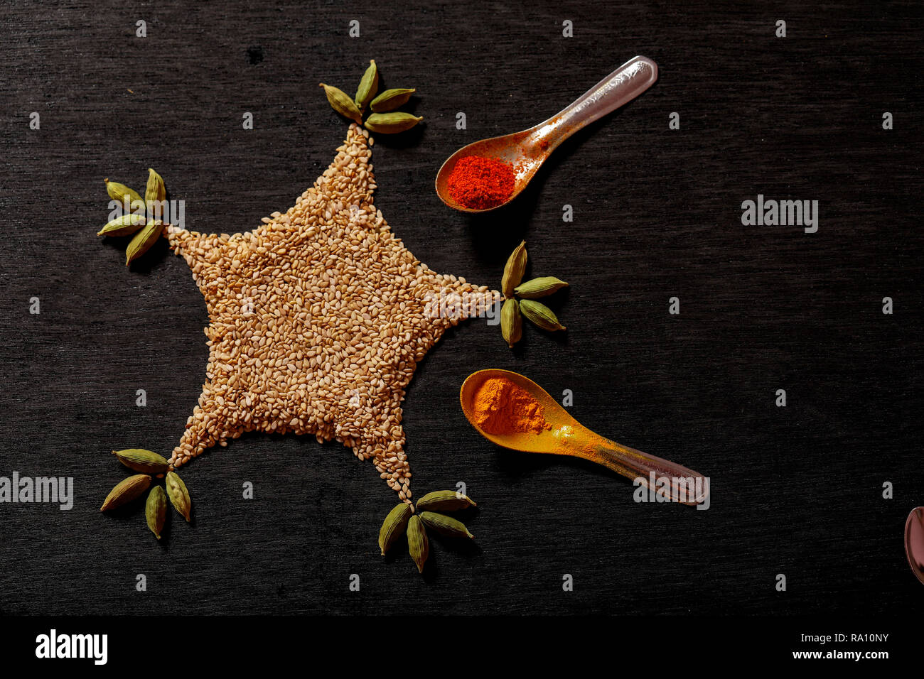 spices in spoons on black background Stock Photo