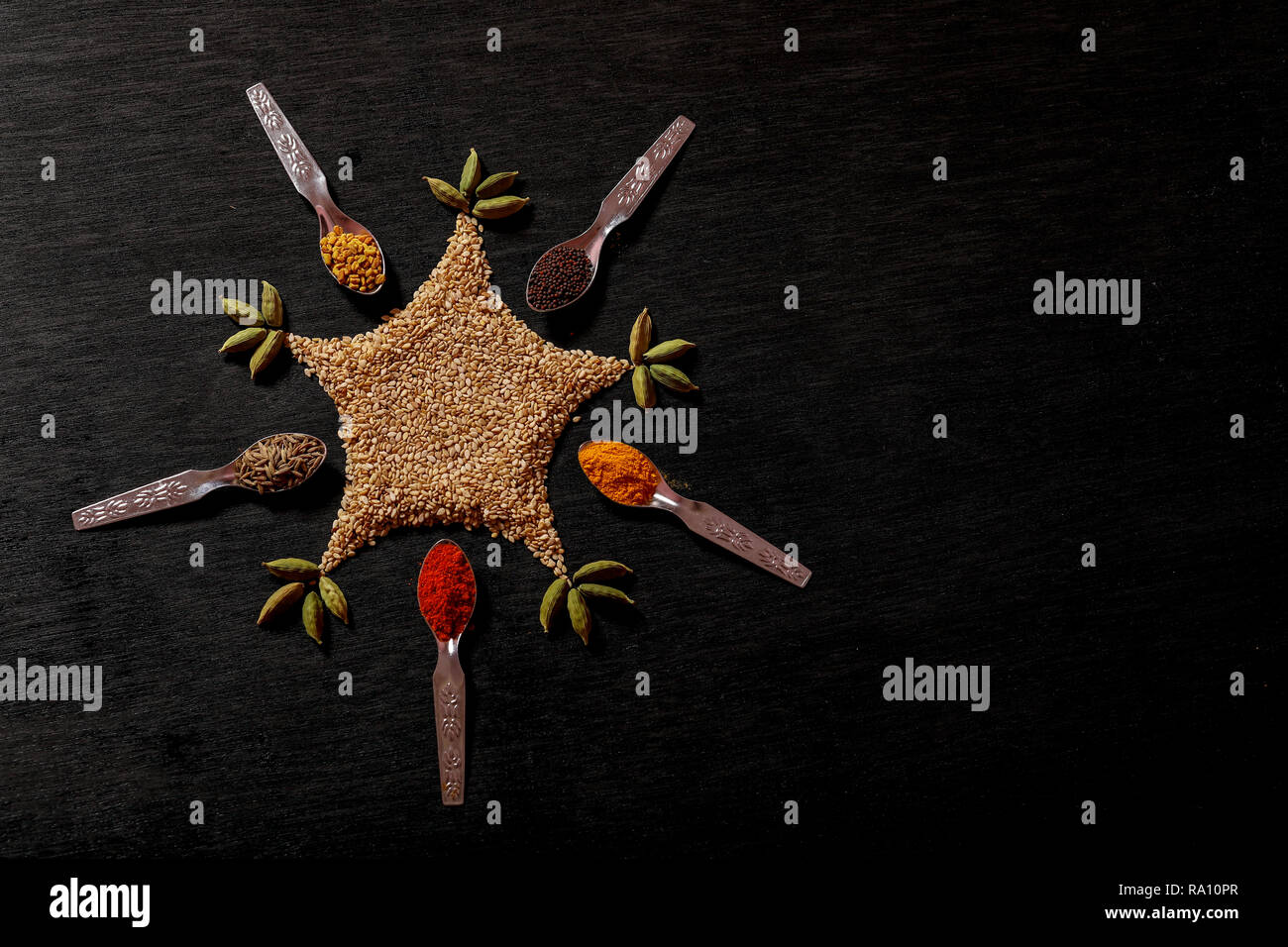spices in spoons on black background Stock Photo - Alamy