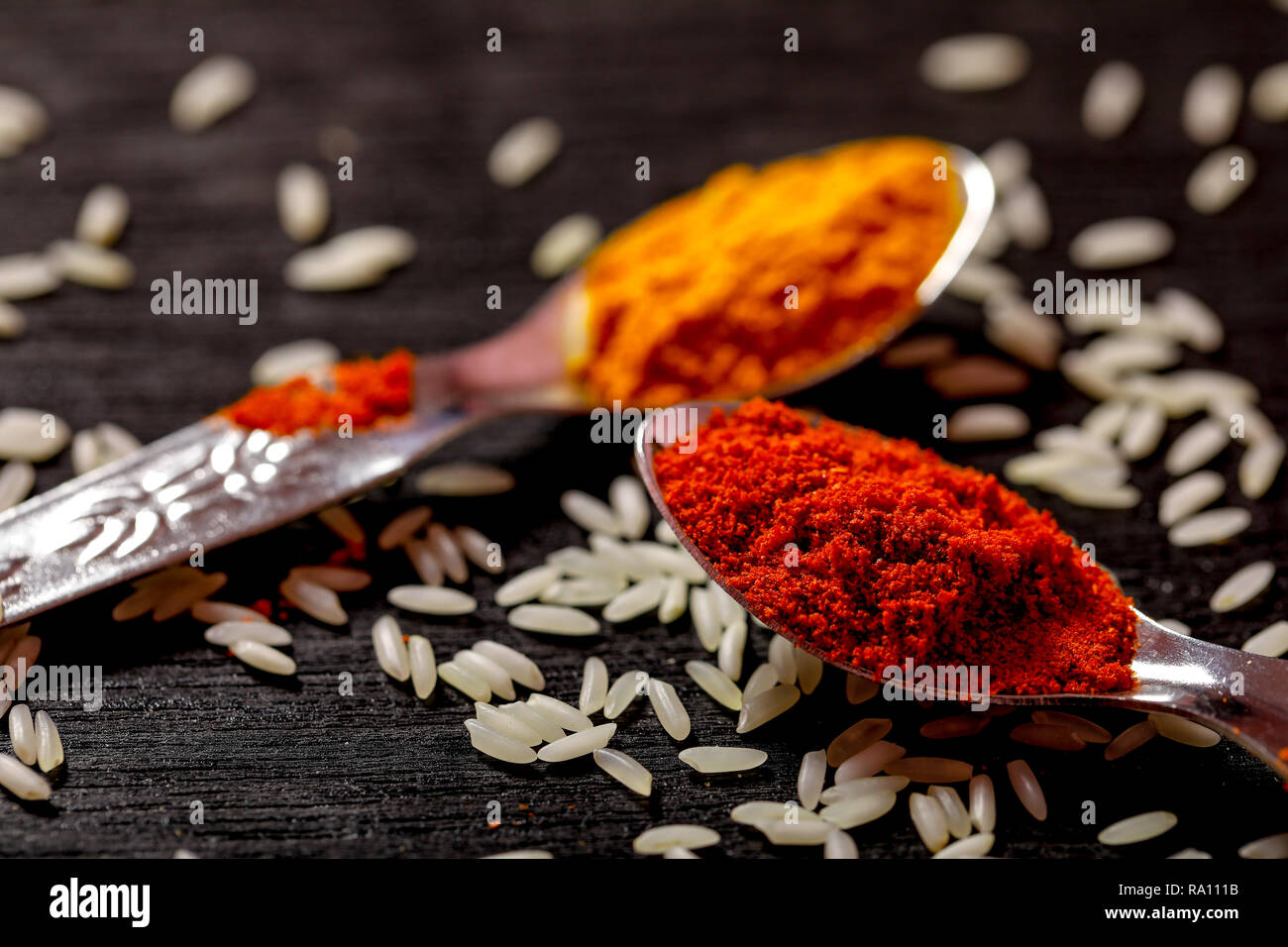 spices in spoons on black background Stock Photo