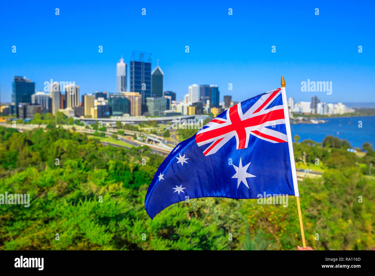 Australian flag waving aver Perth Water, a section of Swan River, and central business district of Perth from Kings park, the most popular visitor destination in WA. Blue sky. Perth skyline aerial Stock Photo