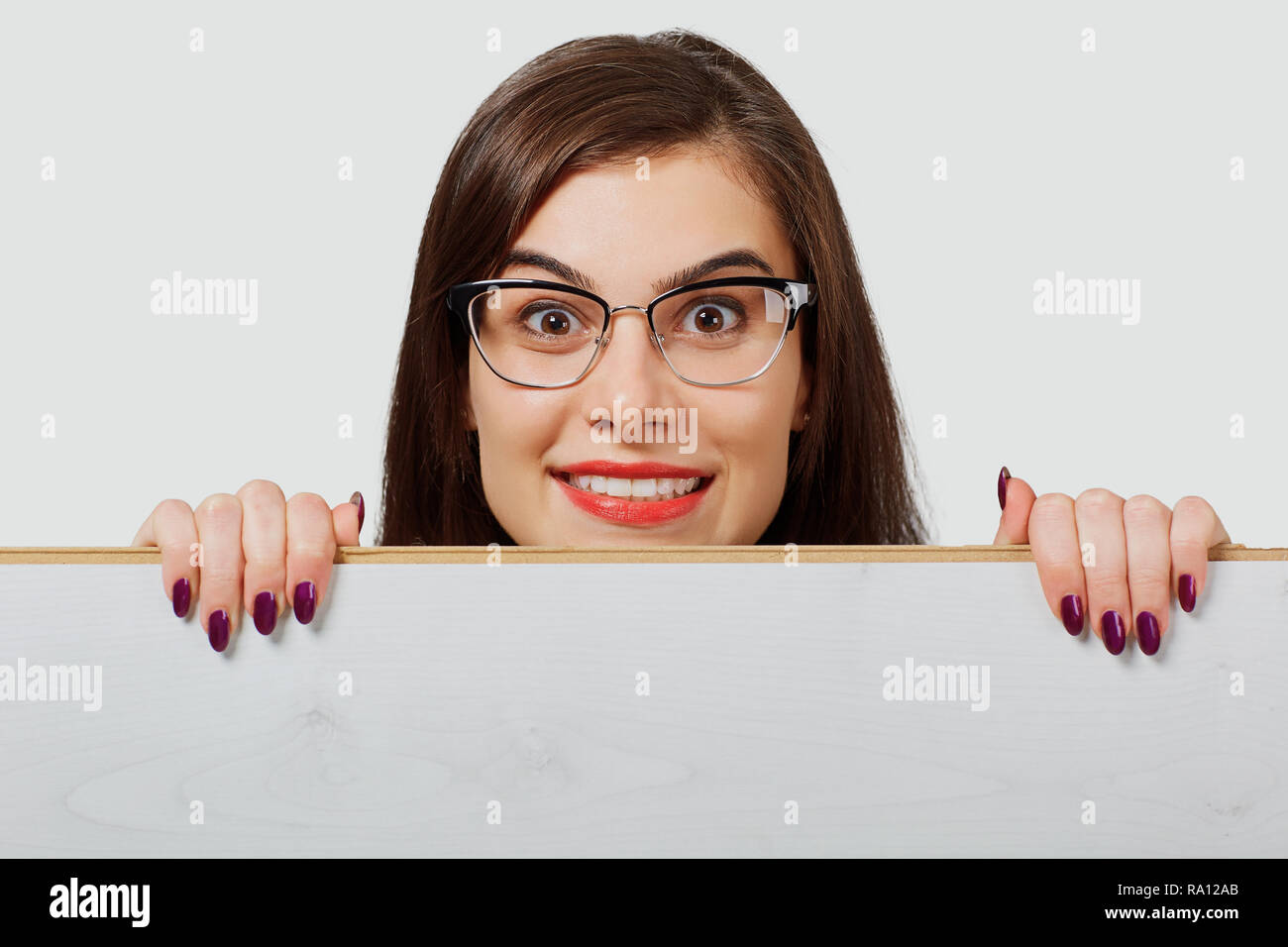 Excited woman behind wood board Stock Photo