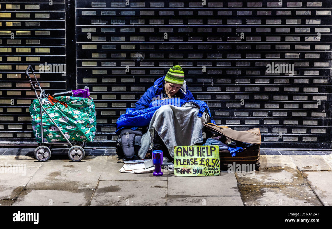 Homeless female begging for money on a pavement, London, England, UK. Stock Photo