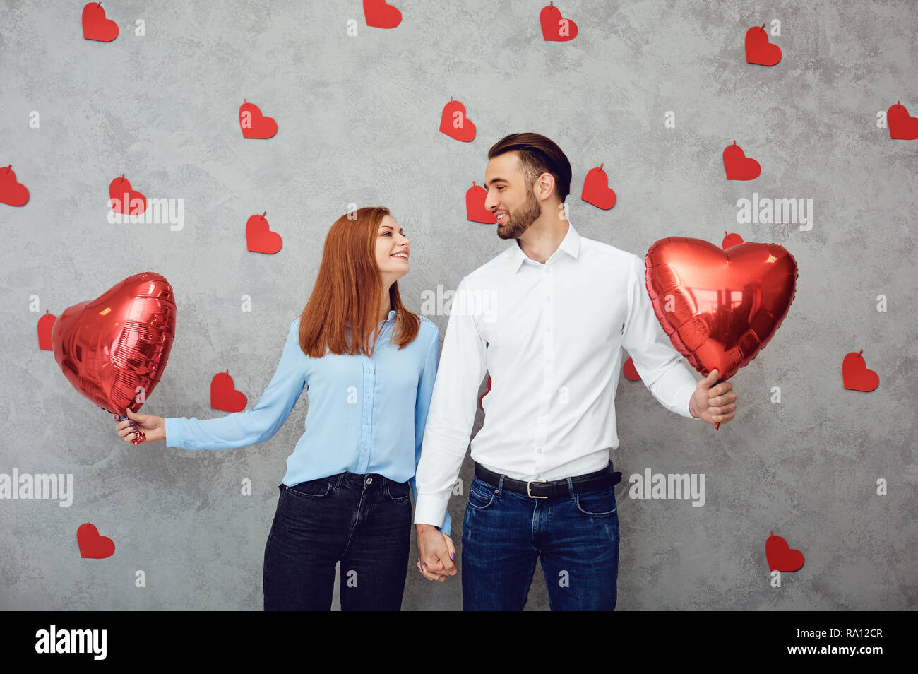 Couple with red heart balloon on a gray background.  Stock Photo