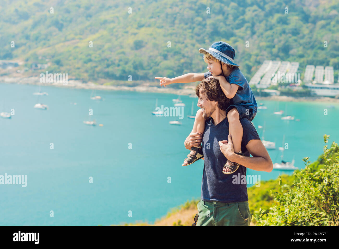 Father and son in the background of Promthep cape and Yanui beach. Phuket, Thailand. Traveling with children concept Stock Photo