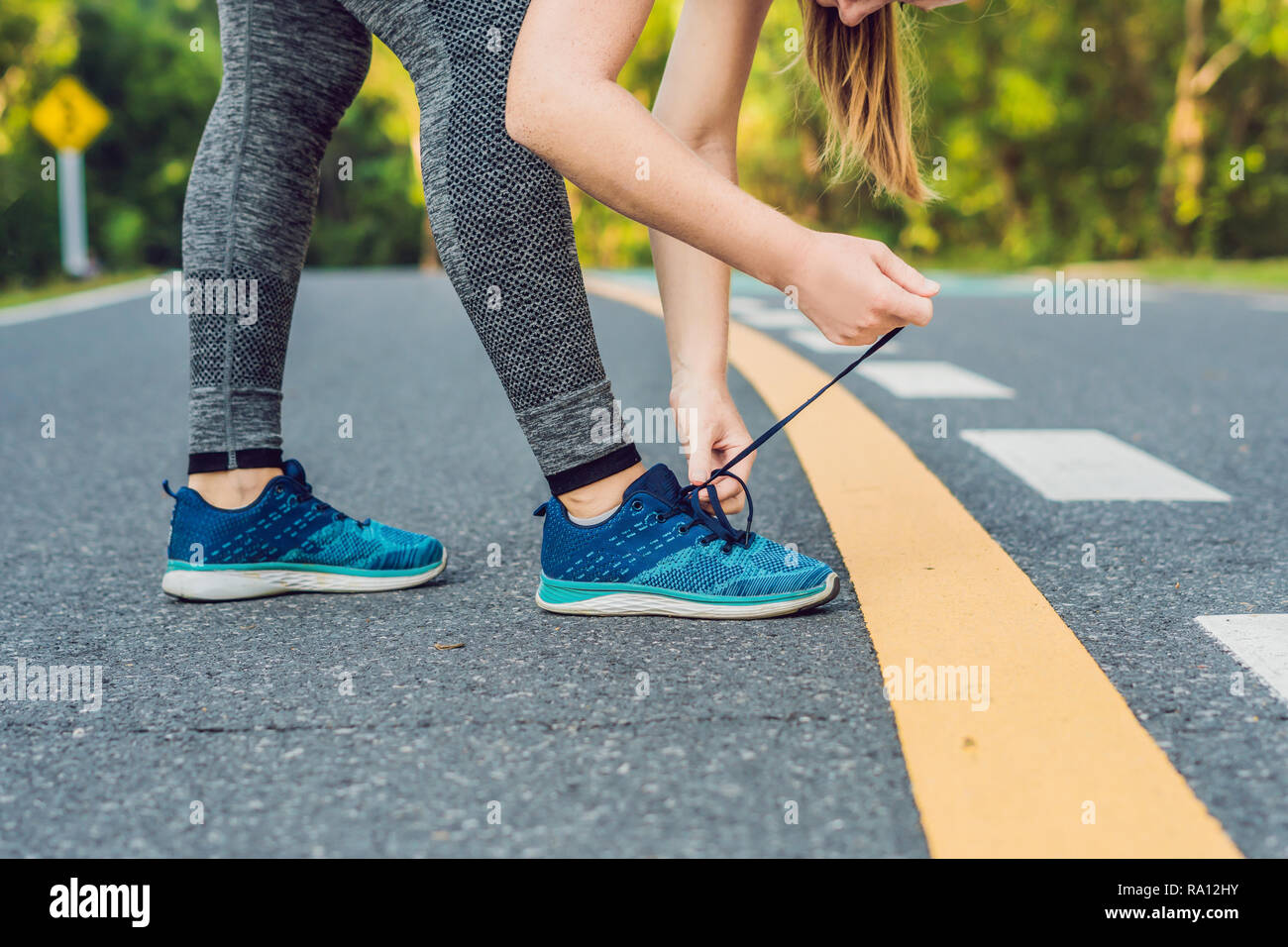 Female runner tying her shoes preparing for jogging outside .Young girld  runner getting ready for training. Sport lifestyle Stock Photo - Alamy