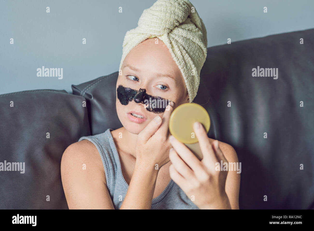 Beautiful young woman relaxing with face mask at home. Happy joyful