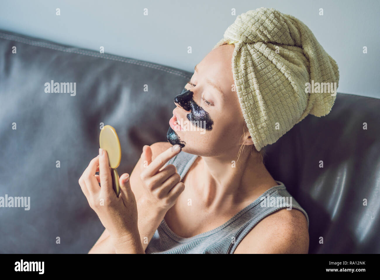 Beautiful young woman relaxing with face mask at home. Happy joyful