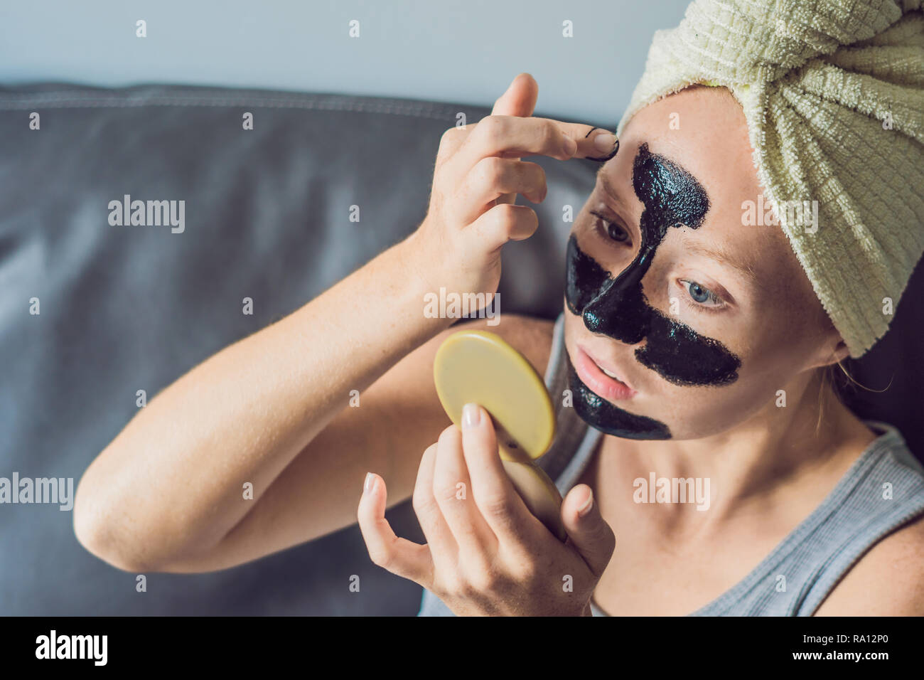 Beautiful young woman relaxing with face mask at home. Happy joyful