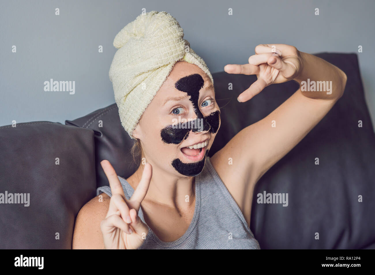 Beautiful young woman relaxing with face mask at home. Happy joyful