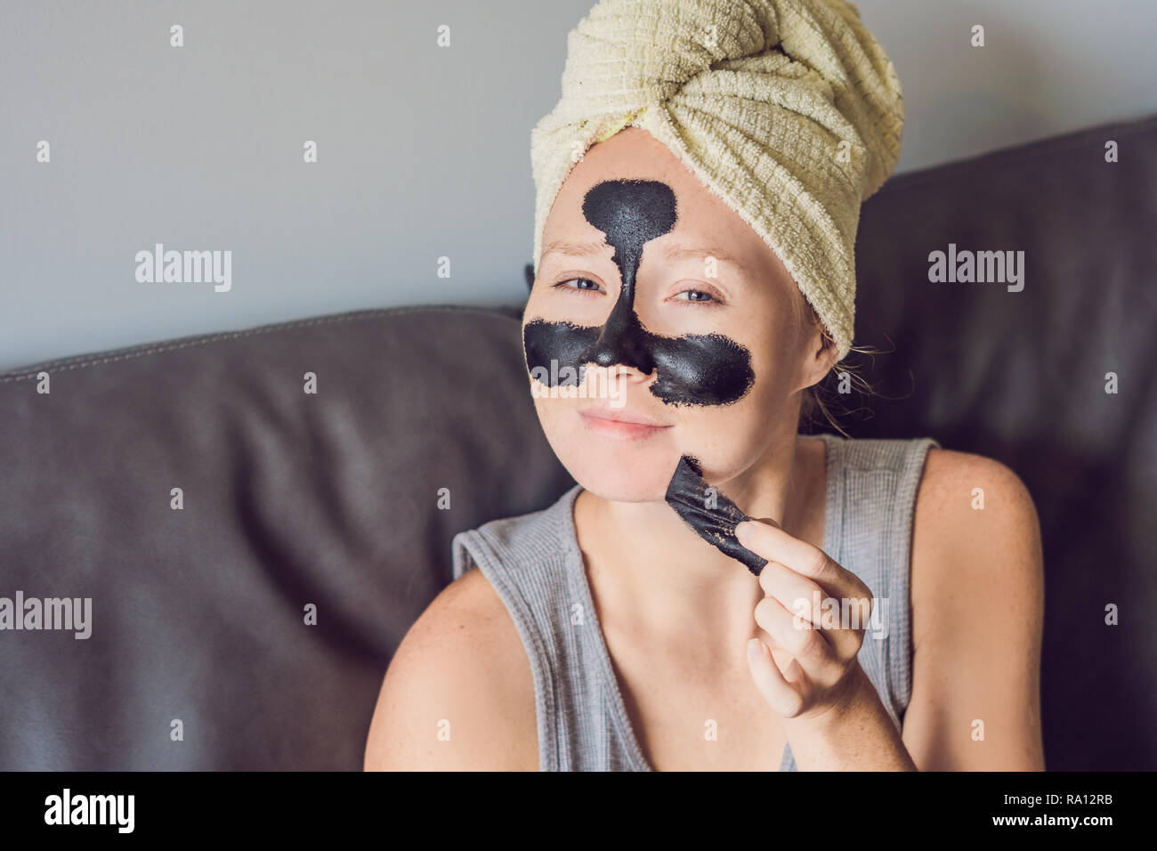 Beautiful young woman relaxing with face mask at home. Happy joyful