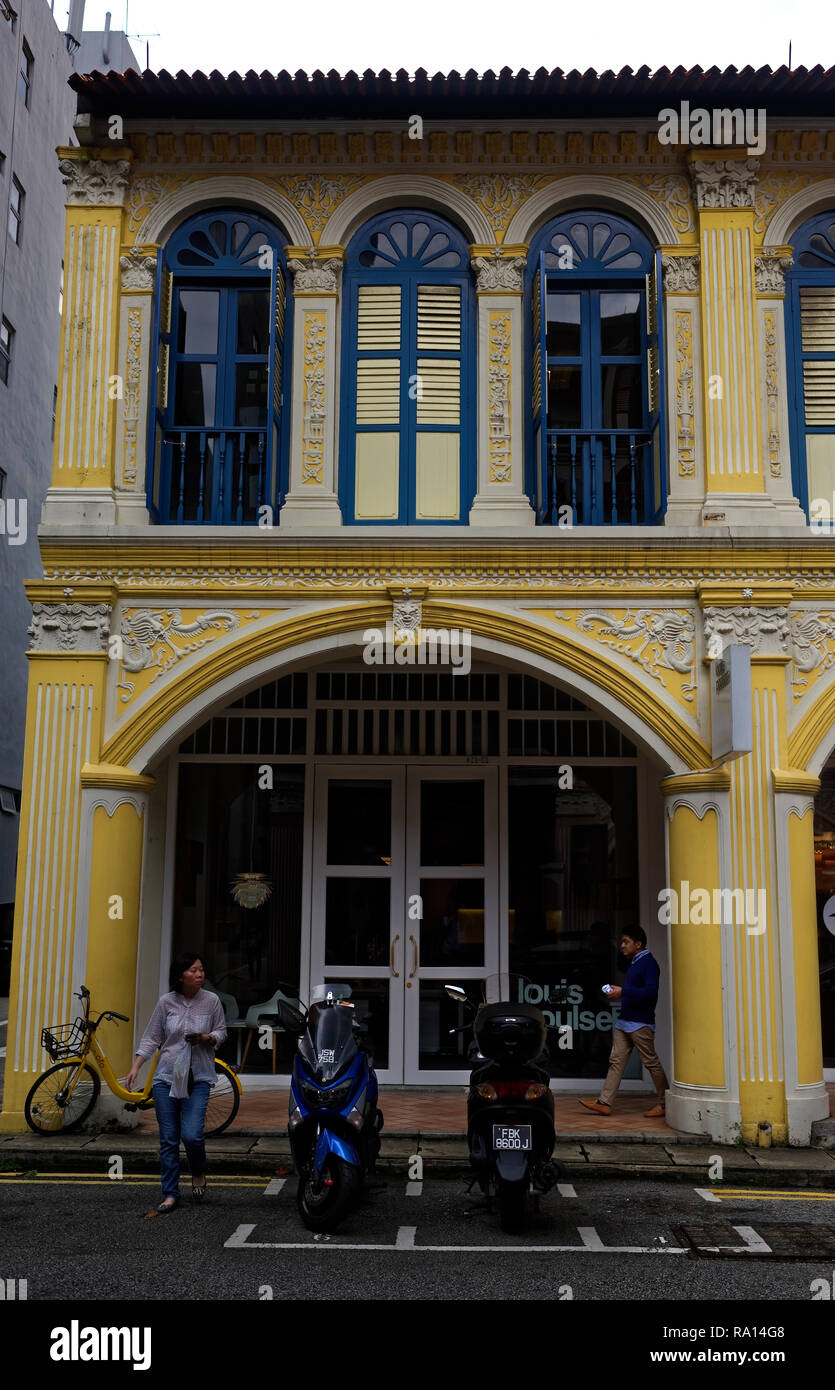 Blue window frames and yellow walls on a traditional Chinese shophouse in Purvis Street, Singapore Stock Photo