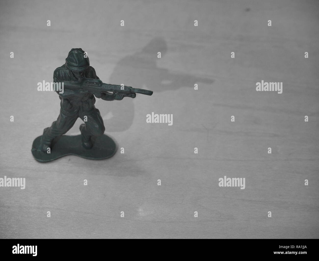 Black and White Image of Green Army Man on Wooden Table Stock Photo